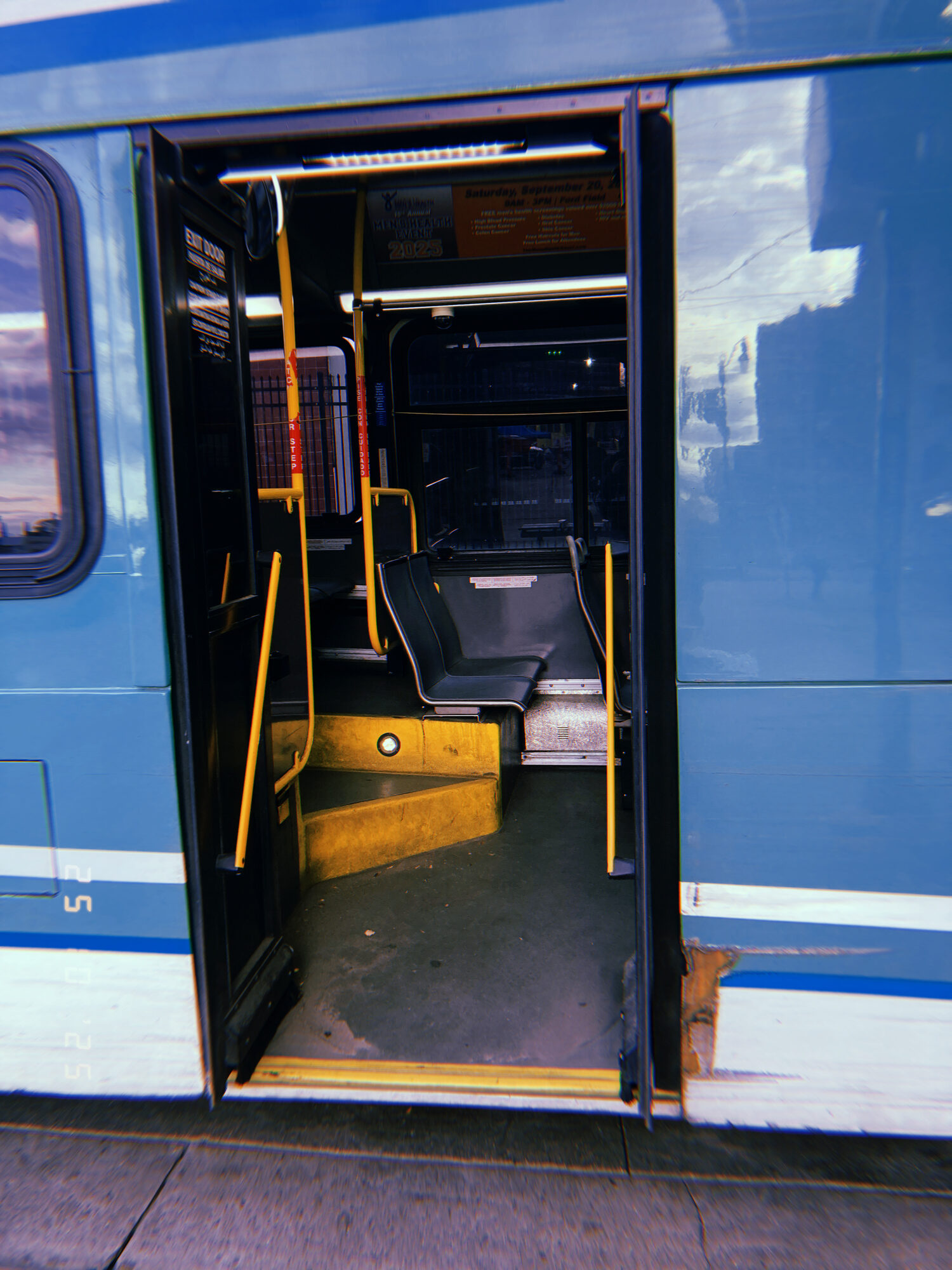 Looking up the steps through the open door of a city bus
