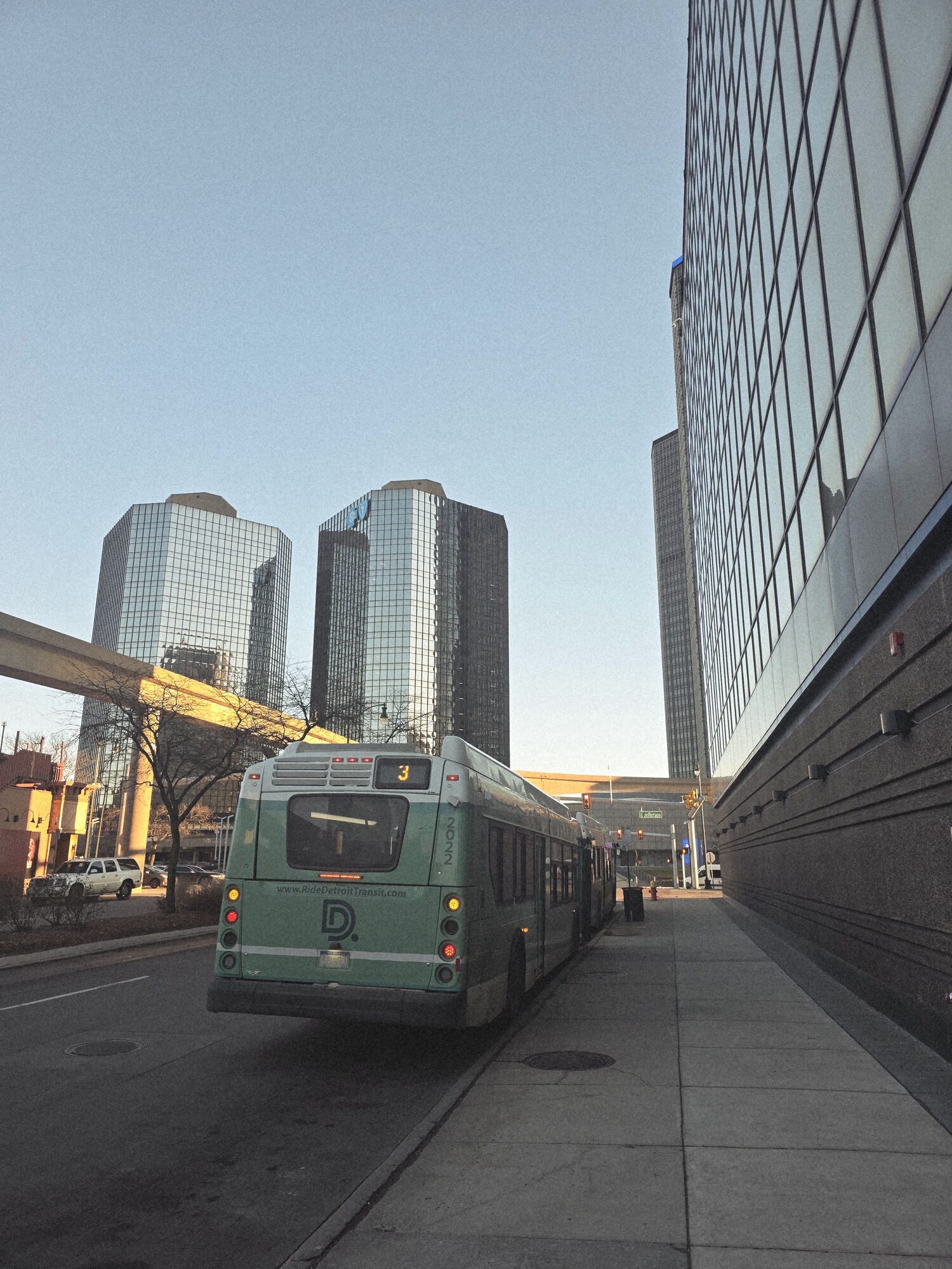 DDOT bus heading down a downtown Detroit street beneath the People Mover track